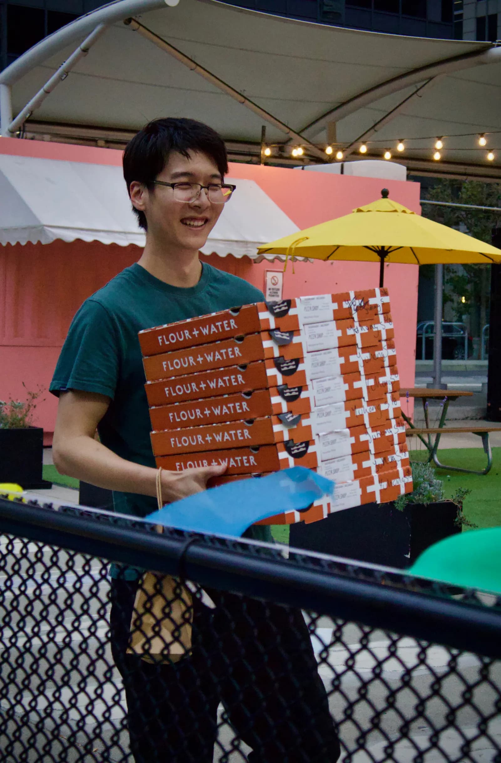 Onyx co-founder, Yuhong Sun, carrying multiple pizza boxes.