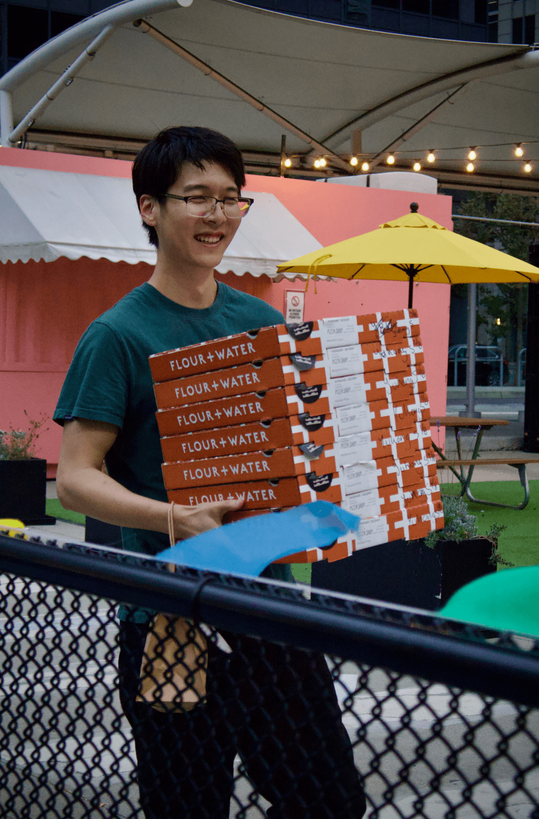 Onyx co-founder, Yuhong Sun, carrying multiple pizza boxes.